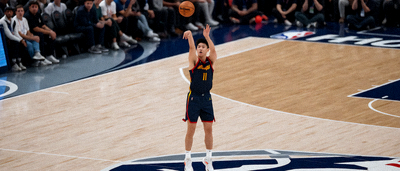 NBA篮球比赛中球员在球场上完成精彩跳投的瞬间，篮球在空中划出弧线
